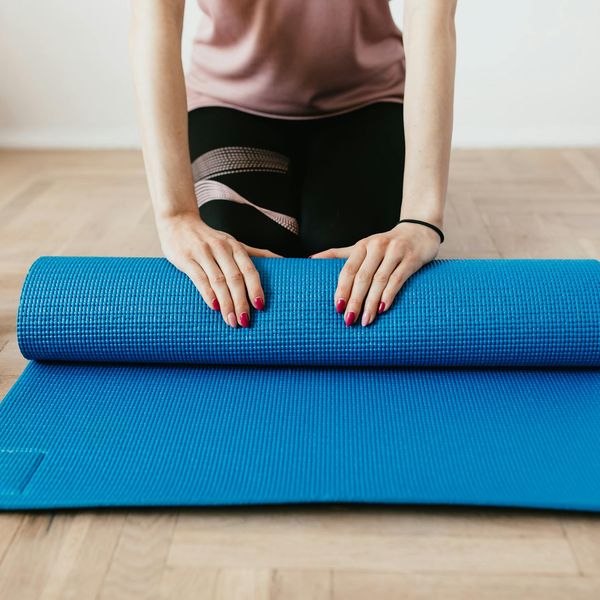 An empty, clean yoga mat on a wooden floor, ready for practice.